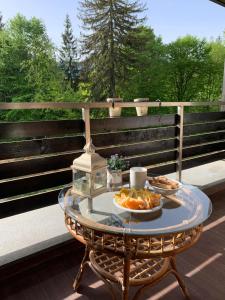einen Tisch mit zwei Teller Essen auf einer Terrasse in der Unterkunft TIAM Apartment Poiana Brașov D117, 3 rooms, 3 terraces, 3 bathrooms in Poiana Brașov