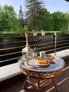 a table with two plates of food on a deck at TIAM Apartment Poiana Brașov D117, 3 rooms, 3 terraces, 3 bathrooms in Poiana Brasov