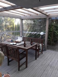 - une terrasse en bois avec une table et des bancs dans l'établissement Domek na Wzgórzu, à Ryn