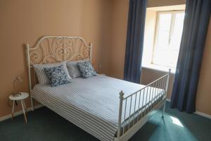 a bedroom with a white bed with blue pillows and a window at Apartments San Rocco in Piran +7 photos