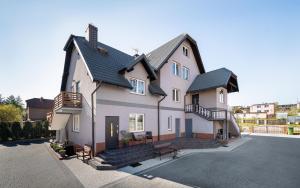 a large white house with a driveway at Dom Latarnika in Jarosławiec