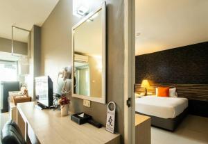 a hotel room with a bed and a mirror at PM Residence in Hat Yai