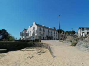 a building on the beach next to a sandy road at Couett'Hôtel Brest Port de plaisance, Les pieds dans l'eau in Brest