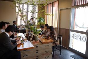 a group of people sitting at tables in a restaurant at ゲストハウス あんだあも in Wakuya
