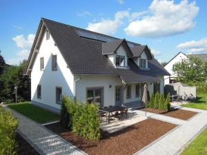 una casa blanca con techo negro en Ferienhaus Sächsische Schweiz, en Kurort Gohrisch