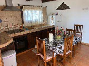 a kitchen with a table and chairs and a kitchen with a refrigerator at Casas Los Abuelos De Calderon in Icod el Alto