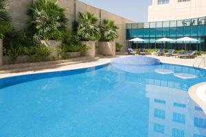 a large swimming pool next to a building at Holiday Inn AlSeeb Muscat, an IHG Hotel in Muscat