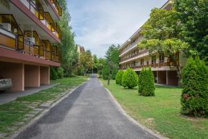 pusta ulica w budynku z drzewami i krzakami w obiekcie Helikon 31 Apartman Keszthely w mieście Keszthely