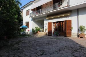 Edificio blanco con balcón y patio en A Casa di Elisabetta, en Santa Maria degli Angeli