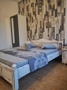 1 cama grande con edredón azul en una habitación en Guest House Аnestievi, en Ahtopol
