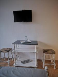 mesa con 2 sillas y TV en la pared en Guest House Аnestievi, en Ahtopol