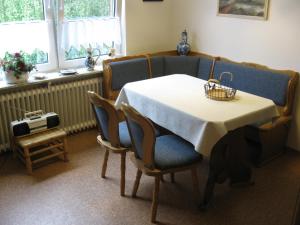 una mesa de comedor con sillas y una cesta. en Ferienwohnung H. Broschinski en Aurich