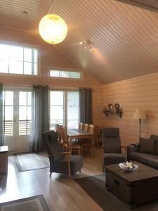 sala de estar con sofá, mesa y sillas en Ähtärin lomamökit - AARRE Mökki, en Ähtäri