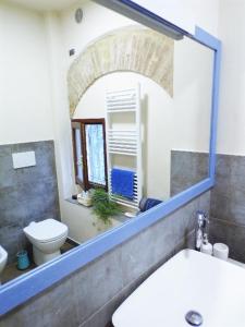 baño con espejo, aseo y lavamanos en A Casa di Giulia, en Siena