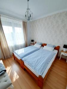 a bedroom with a large bed with a blue blanket at Apartman Nikol in Tihany