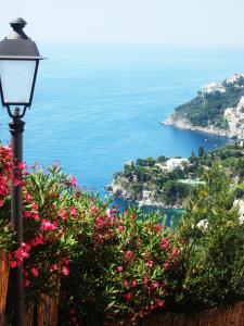 ein Straßenlicht mit Blumen und Meerblick in der Unterkunft L'antica casa-a beautiful view. in Amalfi