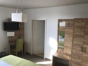 een slaapkamer met een spiegel, een bed en een stoel bij Adam`s Schützenhof in Hornburg