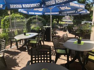 un restaurant en plein air avec des tables, des chaises et des parasols dans l'établissement Adam`s Schützenhof, à Hornburg