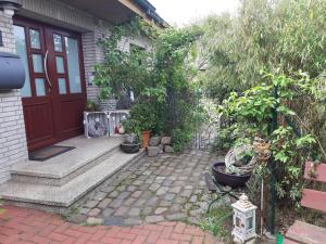 a house with a red door and a patio with plants at Bassener Monteurwohnung in Oyten