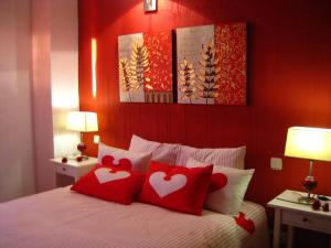 a bedroom with a bed with two red pillows at El Rincón de la Trilla - La Era in Horcajo de la Sierra