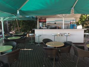 an outdoor restaurant with tables and chairs and umbrellas at Avra Spa Hotel in Loutra Edipsou