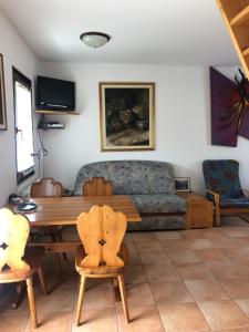a living room with a couch and a table and chairs at Vila Noblesa Apartmaji in Most na Soči