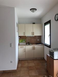 a kitchen with white cabinets and a sink and a window at Vila Noblesa Apartmaji in Most na Soči +20 photos