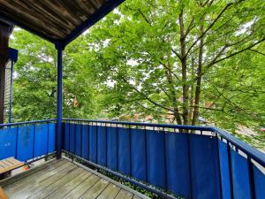 a porch with a blue fence and a tree at City Apartment, 27 qm, 2 Personen, high Sp WLAN in Paderborn +4 photos