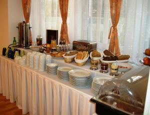 a buffet with plates and food on a table at Hotel Garni Rambousek in Prague