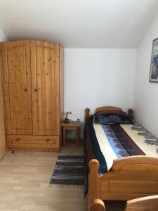 a bedroom with a bed and a wooden cabinet at Vila Noblesa Apartmaji in Most na Soči