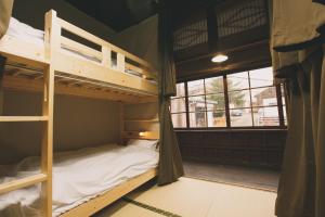 two bunk beds in a room with a window at guesthouse絲 -ito-ゲストハウスイト in Fukumitsu