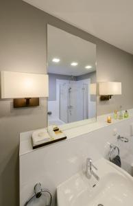 ein Badezimmer mit einem Waschbecken und einem großen Spiegel in der Unterkunft Boutique-Hotel Villa Anna in Eisenach