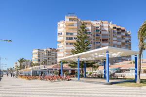 a pavilion with tables and chairs in front of a building at SPECTACULAR VIEWS PENTHOUSE IN 1ST LINE BEACH in Torrox Costa