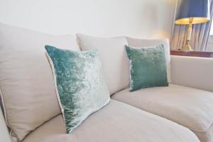 a white couch with two pillows on it at BEACHSIDE SUITE PANORAMIC - PROMENADE HOLIDAY in Nice