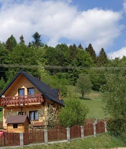 uma casa de madeira com uma varanda em cima em Domek w Pieninach em Grywałd