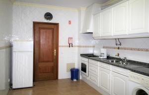 kuchnia z białymi szafkami i brązowymi drzwiami w obiekcie T1 Praia da Rocha/Marina Rocha w mieście Portimão
