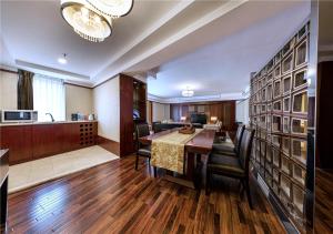 a dining room with a table and chairs and a kitchen at Beijing Kuntai Royal Hotel in Beijing