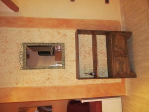 espejo en la pared con armario de madera en Monolocale Borgo Antico, en Castelnuovo di Val di Cecina