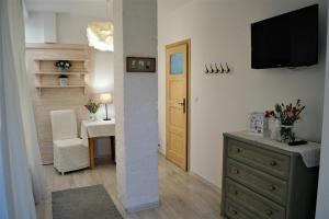 a living room with a dresser and a television on a wall at Pokoje Gościnne Puławska 41 in Kazimierz Dolny