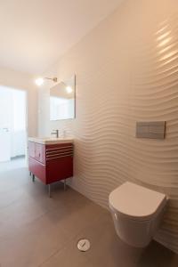 a bathroom with a toilet and a sink and a mirror at Beautiful Studio With Patio Carrapateira in Carrapateira