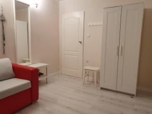 ein Wohnzimmer mit einer roten Couch und einer Tür in der Unterkunft Hotel Wojto in Zamość