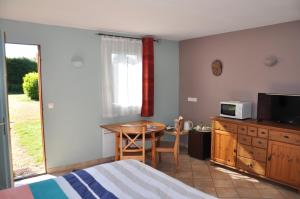 1 dormitorio con cama, mesa y microondas en Chambre d'Hôtes de l'Estuaire, en La Rivière-Saint-Sauveur