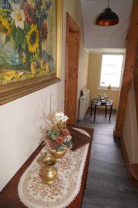 a living room with a table with a painting on the wall at Pension Mitteltorturm in Prenzlau