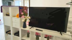 einen Flachbild-TV auf einem weißen Entertainment-Center in der Unterkunft Chafbius apartment in Cagliari