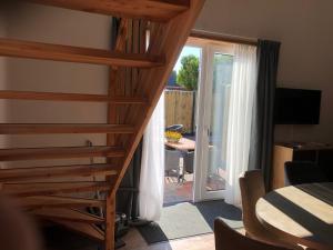 eine Treppe, die zu einem Zimmer mit einer Glasschiebetür führt in der Unterkunft Slaperij Salud! Studios & appartementen in Scharendijke