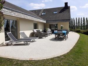 eine Terrasse mit Stühlen und einem Tisch auf dem Rasen in der Unterkunft Gadeyne Nathalie Le chalet de Malvoue in Vimoutiers