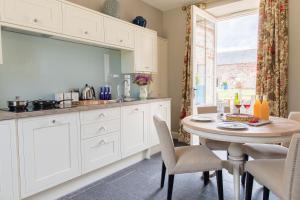 a kitchen with a table and chairs and a window at Newhall Mains in Resolis