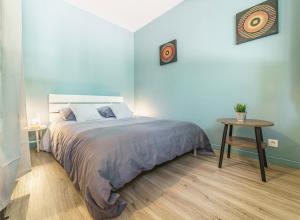 a bedroom with a large bed and a table at Cosy Studio 108 - Chambéry centre - Stationnement - Gare in Chambéry