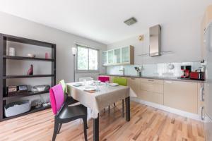 a kitchen with a dining room table and pink chairs at Les Terrasses du Palais in Vannes