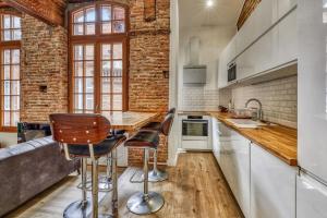 een keuken met een tafel en stoelen en een bakstenen muur bij Charming and luxury flat in Toulouse - Welkeys in Toulouse